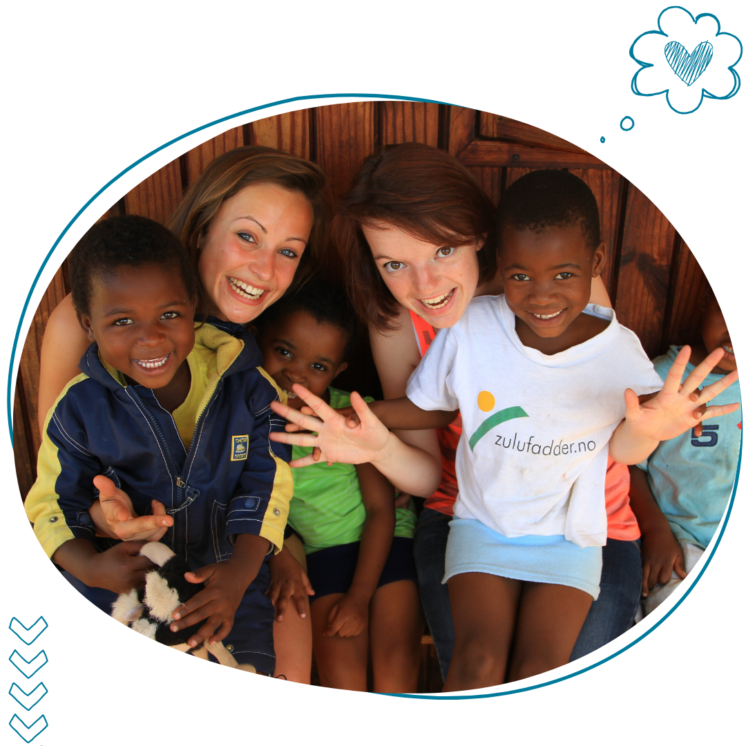 deux adolescentes en colonies de vacances zigotours avec des enfants africains qui sourient sur leurs genoux