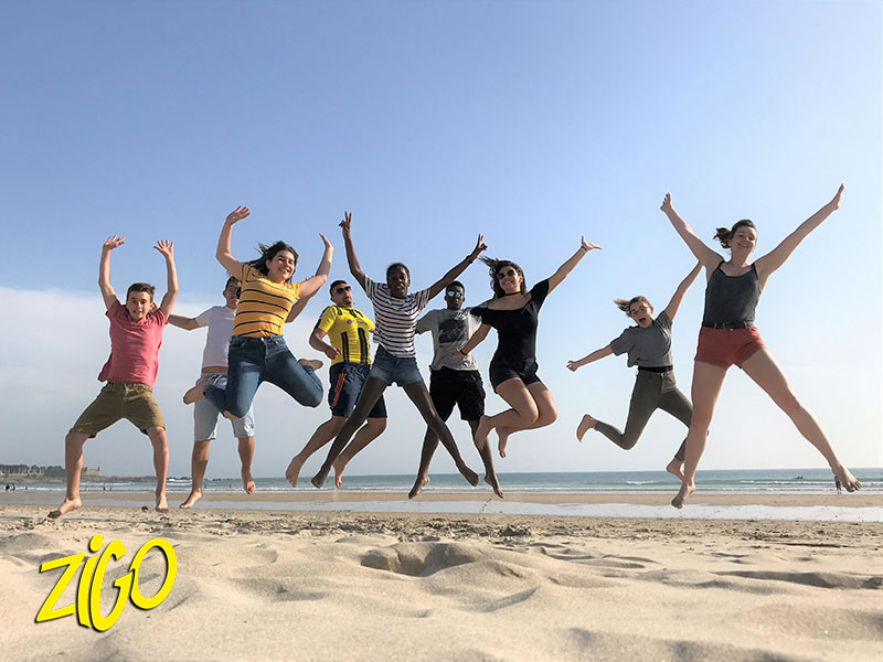 jeunes qui sautent ensemble sur la plage