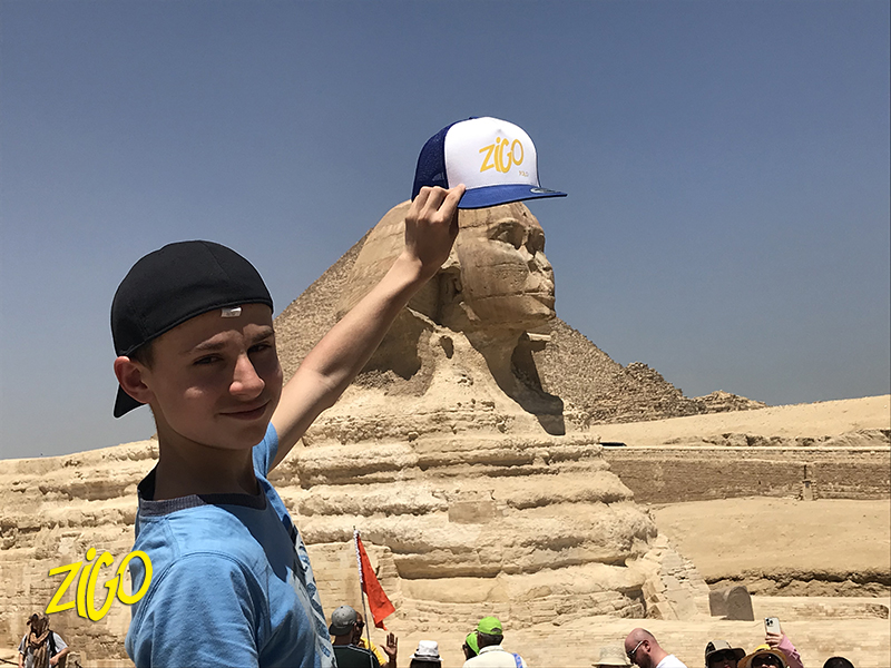 jeune qui tient une casquette au dessus du sphinx
