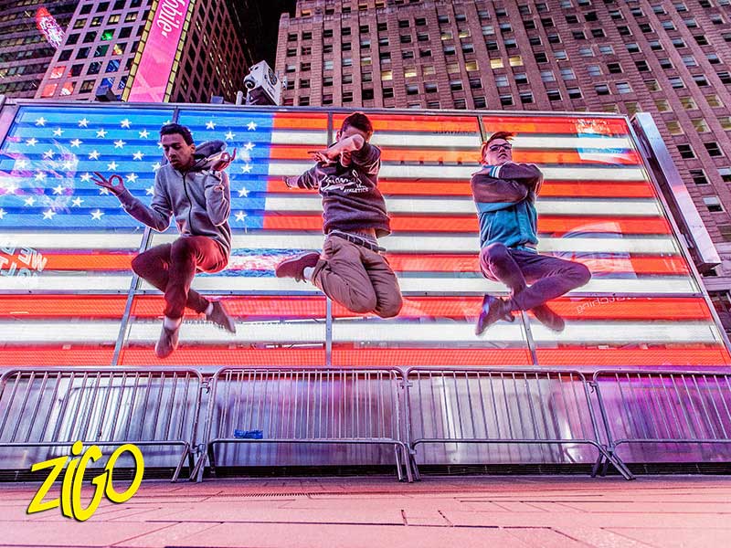 trois jeunes sautant devant un drapeau américain