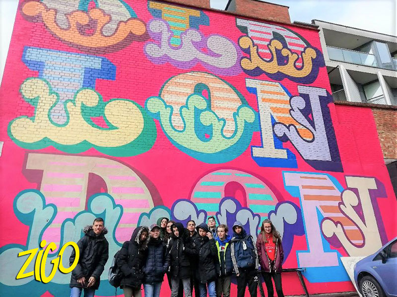 des jeunes devant une œuvre de street art