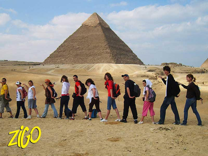 groupe de jeunes marchant devant une pyramide