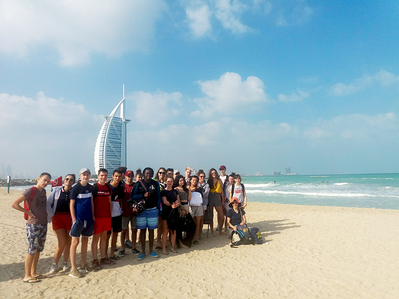 groupe de jeunes sur la plage devant le Burj Arab