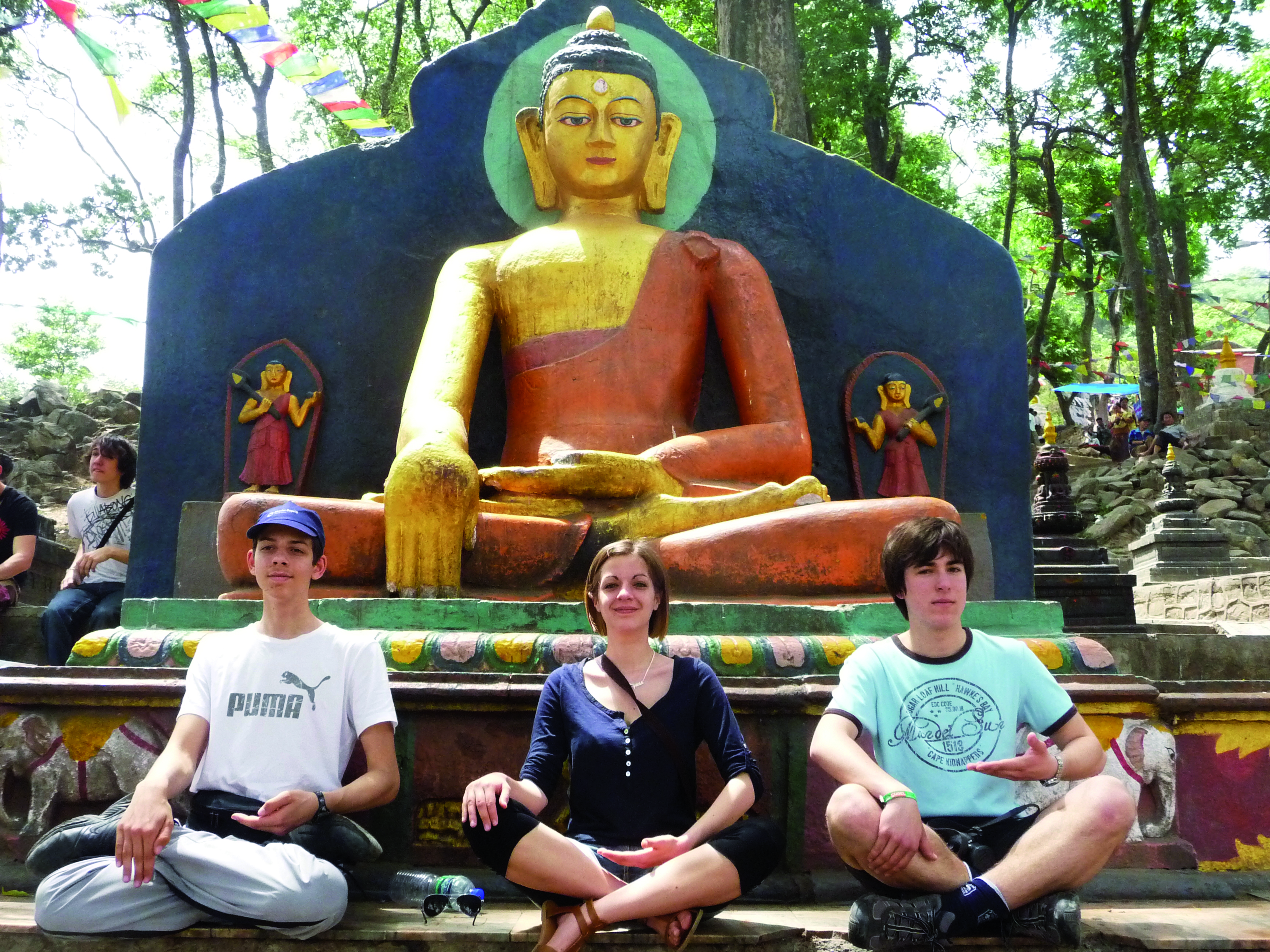 trois jeunes devant une statue